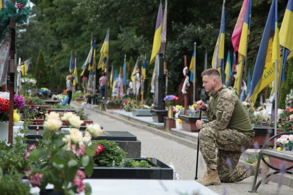 Denys Kovalov hylder en af sine faldne kammerater på en ukrainsk kirkegård.