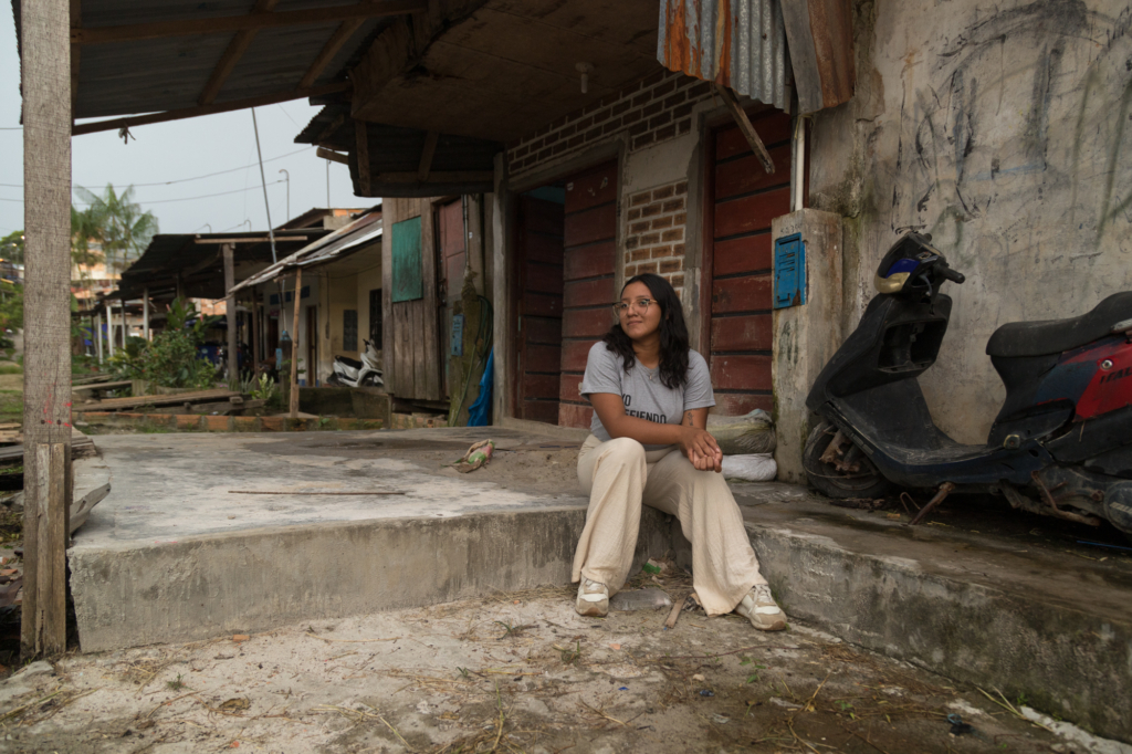 Sofia sidder uden for sit hjem i kvarteret San Juan i Iquitos.