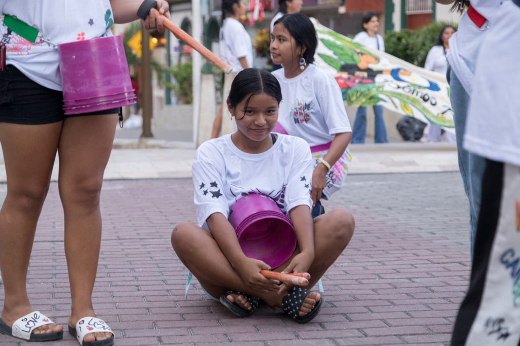 Valeska tager et kort hvil under optoget sammen med kammeraterne fra ONAMIAP og partnerorganisationen MANTHOC
