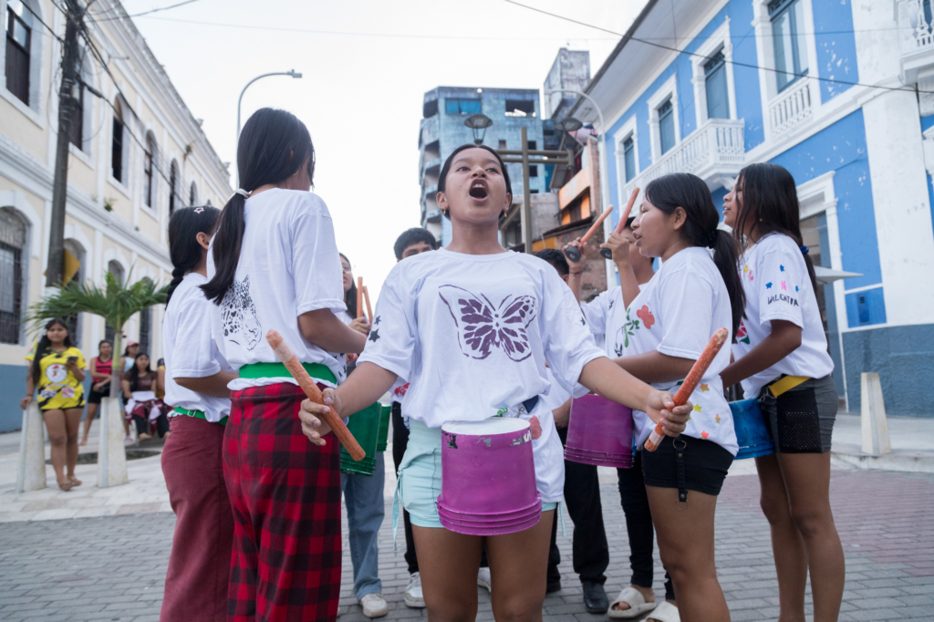 Under et optog gennem Iquitos' gader leder Valeska en del af præsentationen.
