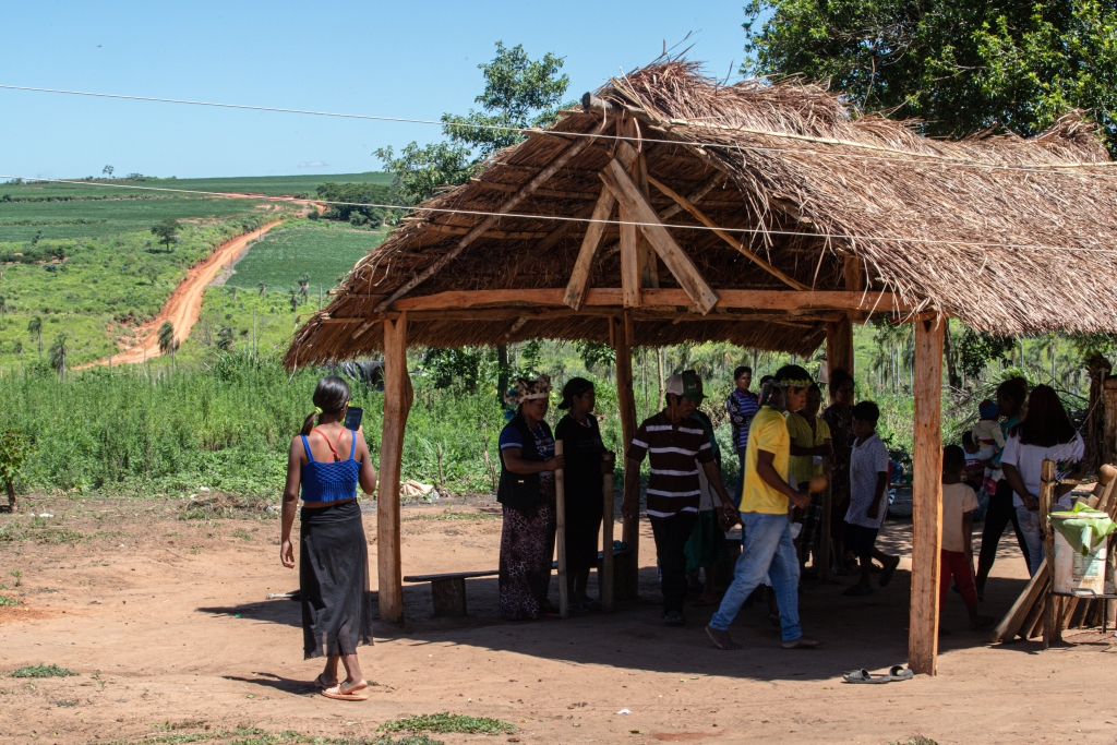 Yukyry-samfundet i gang med jeroky ñembo'e, et spirituelt ritual i oga guasu, der holder dem sammen og, ifølge dem selv, styrker deres håb om at få erstatning og genbosættelse som Avá Guaraní Paranaense-folket. I baggrunden snor den lokale vej sig gennem sojabønnemarkerne.