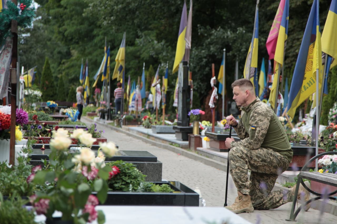 Denys Kovalov hylder en af sine faldne kammerater på en ukrainsk kirkegård.